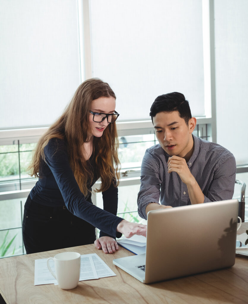 business-executives-discussing-laptop-1-835x1024